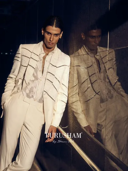 Another shot of the white beaded suit. The play of light on the reflective surfaces and the confident pose create a vibe of dazzling, high-fashion elegance.