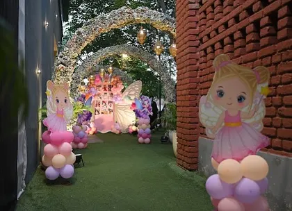A view down the garden path, lined with fairy cutouts and balloon columns, leading to the main butterfly-themed backdrop. We love creating an immersive journey for guests.
