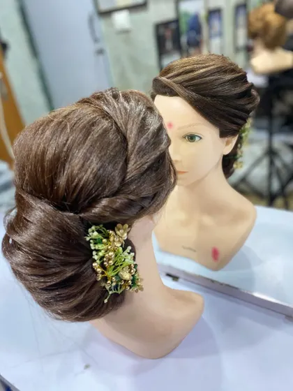A front facing view of the student's work, showing how the updo is reflected in the mirror.