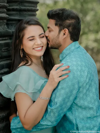 A sweet and candid moment of the groom kissing the bride's cheek. Her joyful, smiling reaction is what makes this photo so special and full of genuine emotion.