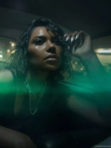 A close-up portrait from the same night shoot, with neon green light flares adding a magical quality. This shows how we use the city's ambient light to create unique visual effects.