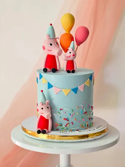 The whole Peppa Pig family is here to party on this blue buttercream cake. Complete with party hats, colourful sprinkles, and balloons, this design is full of cheerful details.