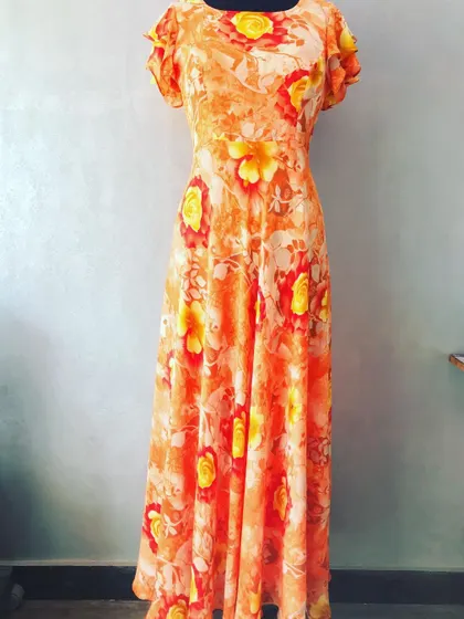 A bright and cheerful full-length gown made from a floral print saree. The flutter sleeves and flowing design make it a comfortable and stylish choice.