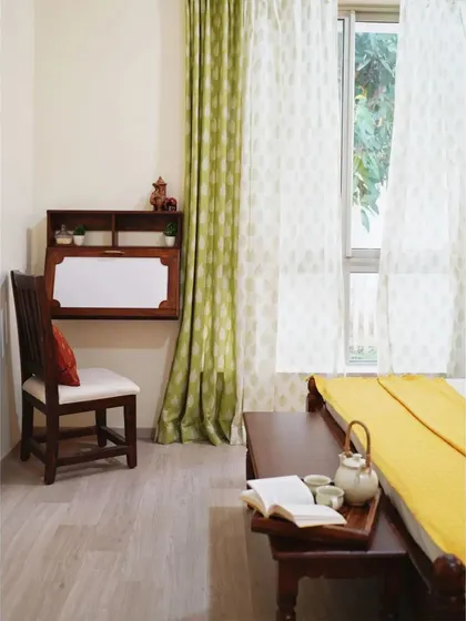 The guest bedroom features a wall-mounted folding work desk, a perfect space-saving solution that provides a functional workspace without cluttering the room.