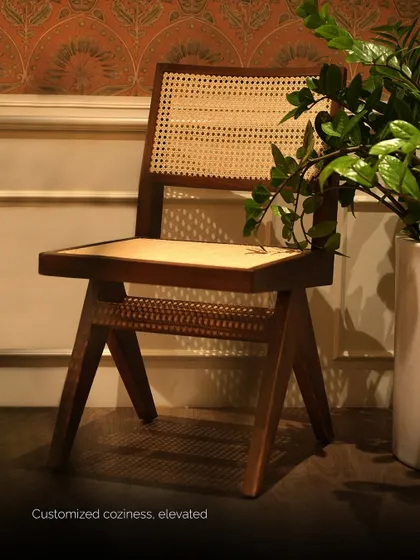 The same cane chair shown in a cozy indoor setting, demonstrating its versatility. The handwoven cane backrest is both breathable and supportive, offering lasting comfort.