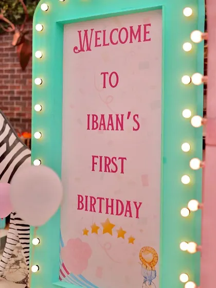 A light-up marquee welcome sign for Ibaan's first birthday carnival. The mint green frame and warm lights create a festive and inviting entrance for all the guests.