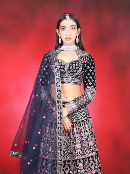 A full-length view of the navy blue embroidered lehenga. In my course, you'll learn how to style makeup for dark, rich outfits.
