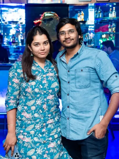 Another happy couple enjoying their time at the pub. The blue-lit bar provides a cool and romantic backdrop.