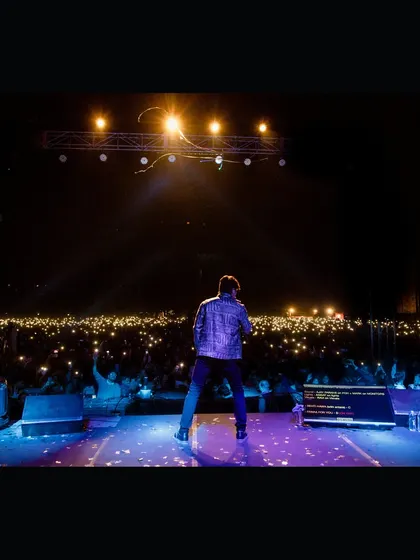 A powerful shot of singer Shaan facing a sea of lights from the audience at IIT Dhanbad. We create moments that connect artists with their fans for an unforgettable concert experience.