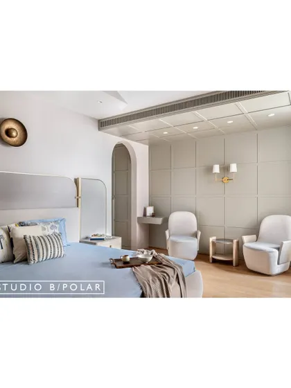 The parents' bedroom at Sunlit Serenity has an earthy and light aesthetic. The feature wall has contemporary moldings that extend onto the ceiling, adding architectural interest.
