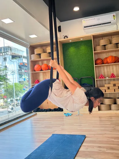 A student gracefully floats in a suspended plank pose, engaging her core and building upper body strength.