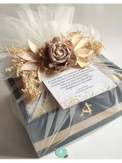 A wedding hamper wrapped in delicate tulle with a beautiful handmade flower on top. This finishing touch makes the gift truly stand out.