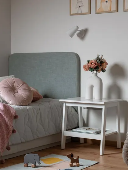 This kids' bedroom is designed with plenty of open space for playing. The bed is snugly placed in a corner to create a cozy nook, and a built-in study area with convenient storage makes the room balanced and functional.