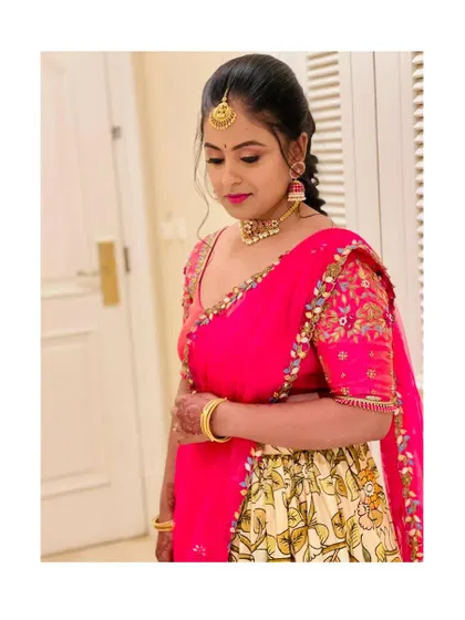 A closer look at the hand-embroidered blouse and vibrant pink dupatta of the custom half saree. The intricate floral embroidery adds a rich, celebratory feel.