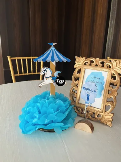 A close-up of the charming carousel centerpiece with a blue paper flower.