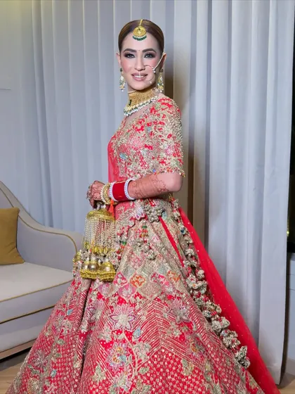 A full-length shot of my beautiful bride Yukti. Her magnificent red lehenga is the star, and the makeup is crafted to complement its grandeur without overpowering her natural beauty.