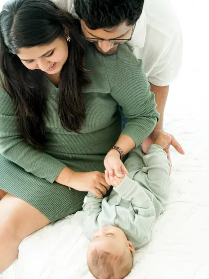 A playful moment during a newborn session. Gentle interactions like holding hands and counting tiny fingers result in sweet, authentic photographs you will treasure.