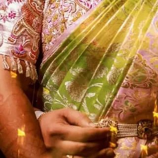This shot focuses on the sleeve and body of the blouse, showing how the embroidery work flows seamlessly across the piece. The combination of pink, red, and gold threads creates a vibrant effect.