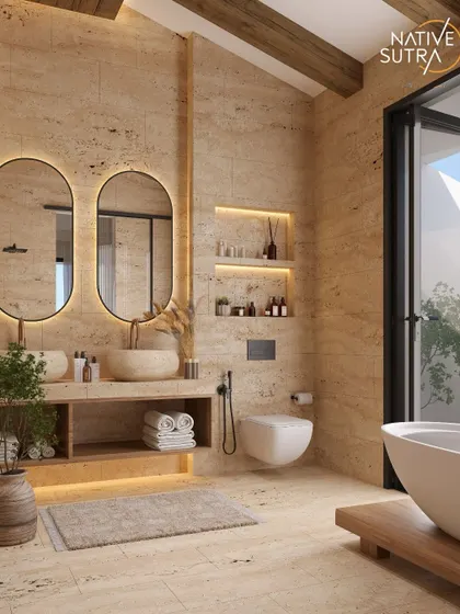 A spa-inspired bathroom featuring travertine-style tiles, a stone basin, and a freestanding tub. Backlit mirrors and integrated lighting in the niches add a soft, ambient glow, creating a space where calm meets craftsmanship.