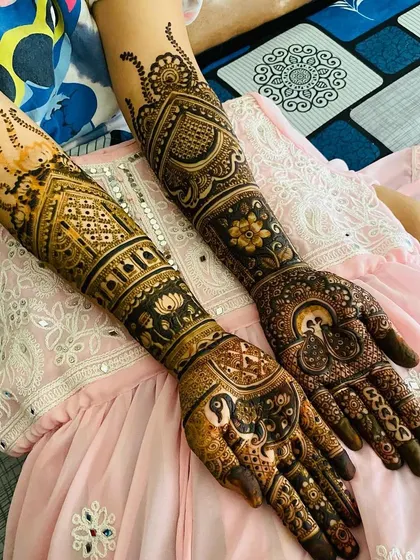 This design combines architectural elements with classic motifs like the peacock and lotus. The result is a unique and sophisticated full-arm bridal mehndi.