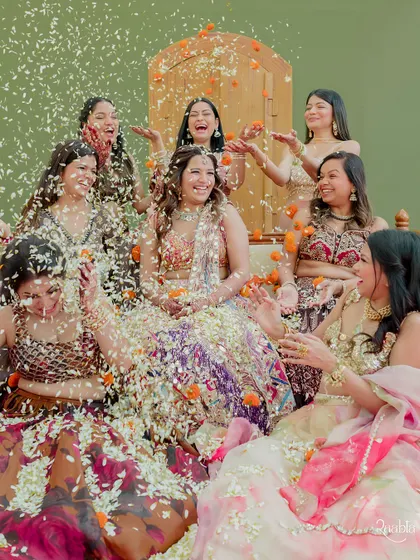 The bride and her bridesmaids having a blast, showering each other with flower petals in a moment of shared happiness.