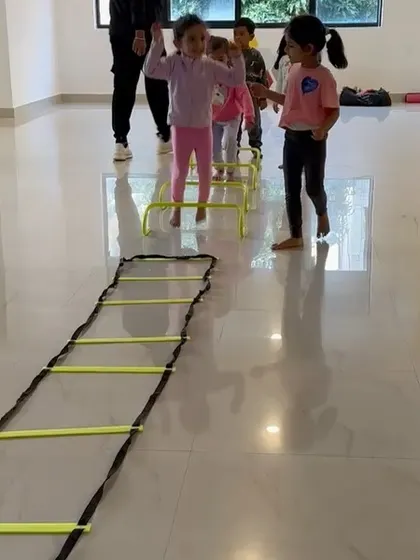 Kids line up to take their turn at an agility hurdle drill. We use professional equipment, adapted for their size, to teach athletic skills correctly and safely.