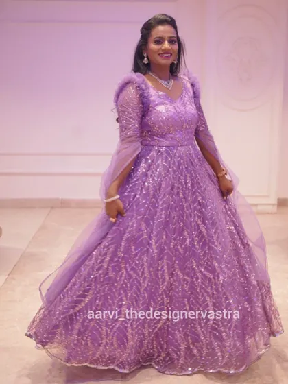 A full view of Tharuna's gorgeous lavender gown. The feathered sleeves and cape add a touch of drama and elegance.