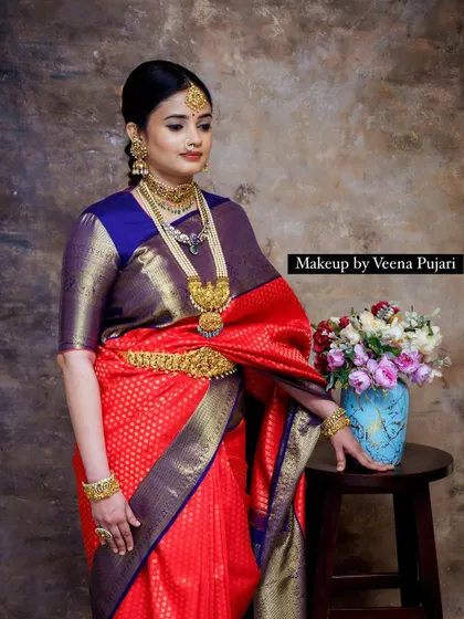 A standing portrait from the vintage shoot. The red and blue saree, paired with classic makeup, creates a look reminiscent of old paintings.