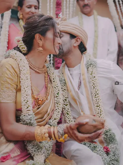 An intimate kiss during the ceremony, a moment of modern love within a traditional setting.