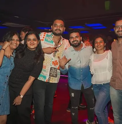 A fun group of friends posing for a photo while enjoying the party.