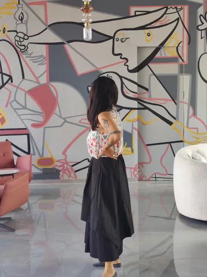 The artist standing before the reimagined 'Guernica' mural, providing a sense of scale and the personal connection we forge with each project.