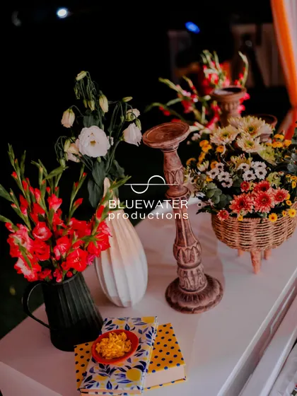 A collection of rustic props and vibrant flowers on a tabletop, adding to the charming, eclectic feel of the 'Dolce Vita' Haldi.