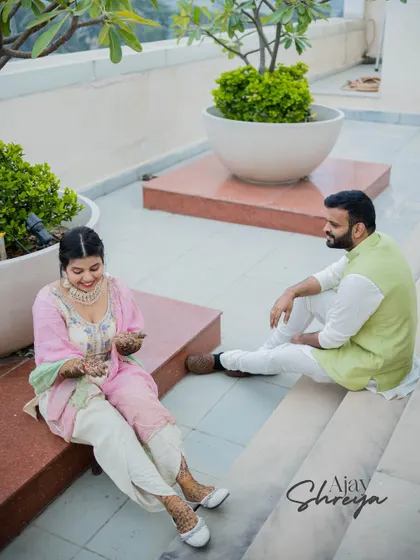 A candid shot of a couple sharing a moment on a terrace. This photo captures the relaxed and informal side of pre-wedding celebrations.