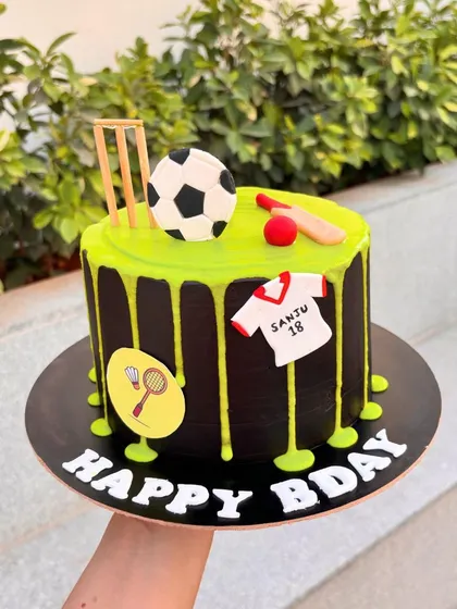 For the ultimate sports fan, this cake combines cricket, football, and badminton. The black cake with a neon green drip makes the design really stand out.