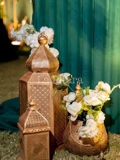 A close-up of the decorative elements, showing ornate golden Moroccan-style lanterns paired with vases of white roses. These details added a touch of luxury and warmth to the decor.