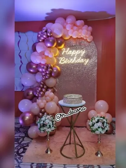An elegant arch backdrop with a rose gold balloon garland, perfect for birthdays, anniversaries, or bridal showers.