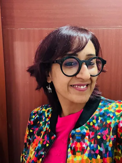 A close-up selfie showing off my quirky camel earrings and colorful jacket.