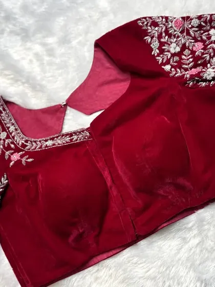 A luxurious red velvet blouse with a modern collar neck and sleeves covered in intricate silver and pink floral embroidery.