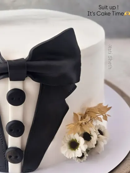 A close-up of the tuxedo cake, showing the sharp details of the suit and the small floral boutonnière.