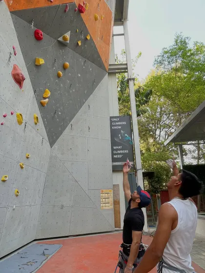 Two climbers discuss strategy before attempting a route on our outdoor lead wall. Beta sharing, or sharing tips, is a huge part of the climbing community.