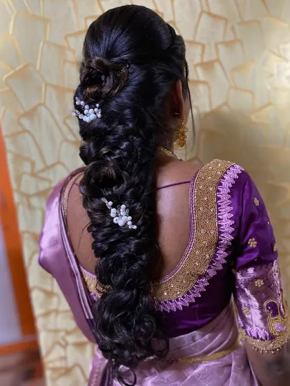 A messy fishtail braid accessorized with delicate pearl and flower clips. This is a romantic and soft style, ideal for an engagement or pre-wedding shoot.