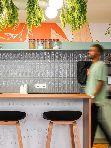 A close-up of the pantry bar, showing the detailed design elements like the perforated counter front and modern bar stools that contribute to the space's unique character.