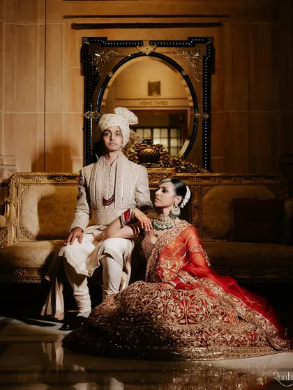 A classic, regal portrait of Amala and Aditya inside the Umaid Bhawan Palace, as featured in ELLE India. This shot captures the timeless elegance of their wedding attire and the opulent setting.