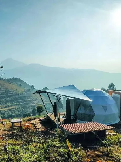 For this glamping project, we used a rustic aesthetic with exposed concrete and brick-lined pathways to blend the structure into the rugged landscape.