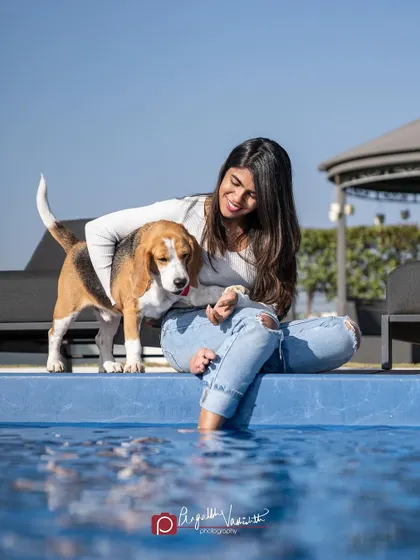 A candid moment of a girl dipping her feet in the pool while her Beagle looks on. These relaxed, lifestyle shots are full of warmth.