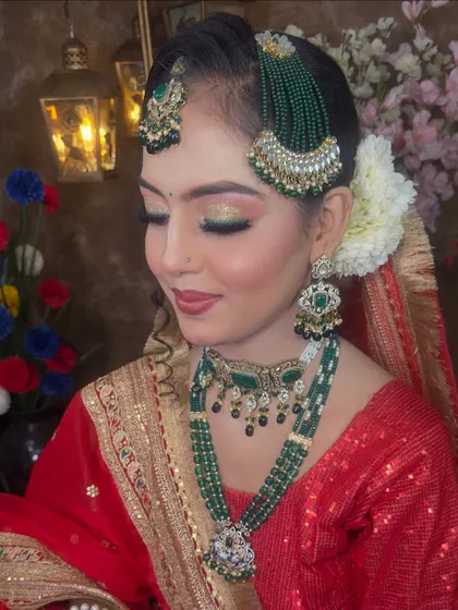 This shot focuses on the eye makeup and the detailed jewellery. The combination of gold, green beads, and pearls makes this set a timeless choice for any bride.