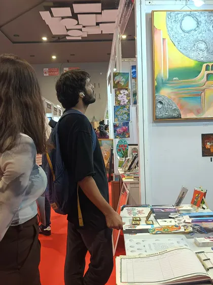 I love watching people connect with my art. This visitor is looking closely at my surrealist painting "Vo Shaam" at 'The Haat of Art'. Seeing my work resonate with others is the real win for me.