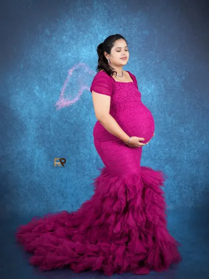 Glowing in magenta. This mermaid-style ruffled gown is a client favorite, and it looks absolutely stunning against our celestial blue backdrop with added angelic effects.