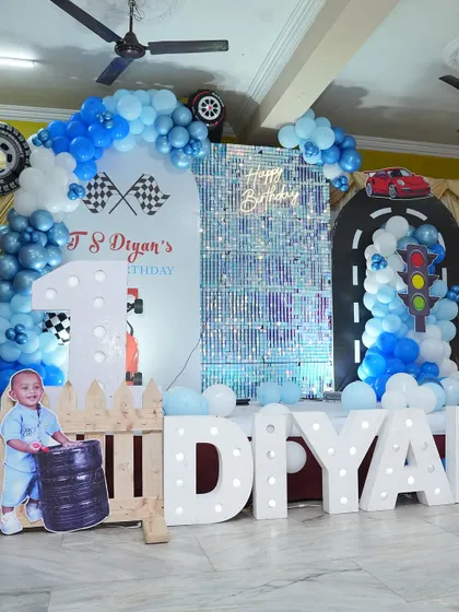 A first birthday is a huge milestone, and we went all out for this car-themed party. The setup included a custom backdrop with a race track, a shimmering panel, large light-up letters spelling the birthday boy's name, and of course, plenty of themed cutouts and balloons.