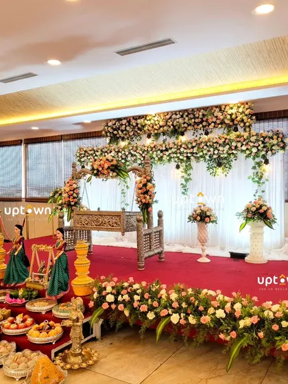 A wide shot of the naming ceremony stage, showing the full floral arrangement and guest offerings.